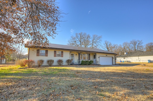 ranch-style home featuring a porch, a garage, and a front yard