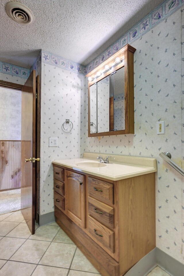 bathroom with tile patterned floors, vanity, and a textured ceiling