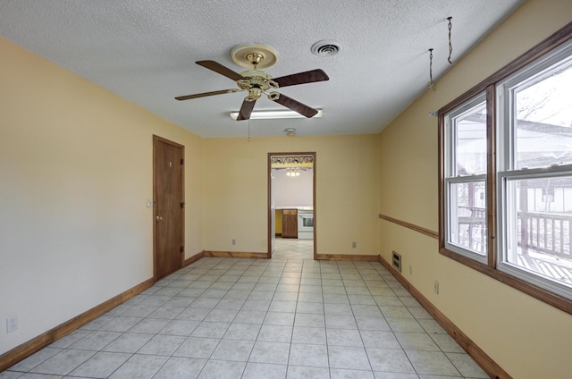 tiled spare room with a textured ceiling and ceiling fan