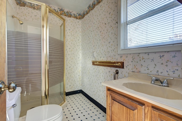 bathroom with tile patterned floors, vanity, toilet, and a shower with shower door