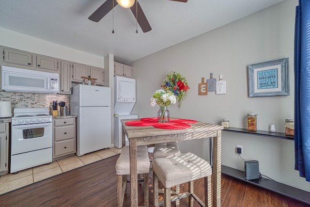 29 Fall Creek Dr Unit 2, Branson, MO 65616 - kitchen featuring white appliances, stacked washer and clothes dryer, ceiling fan, gray cabinets, and decorative backsplash