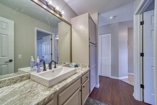 29 Fall Creek Dr Unit 2, Branson, MO 65616 - bathroom featuring vanity, wood finished floors, and a textured wall