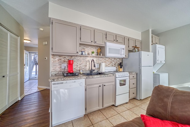 29 Fall Creek Dr Unit 2, Branson, MO 65616 - kitchen with white appliances, stacked washer and clothes dryer, decorative backsplash, light countertops, and open shelves