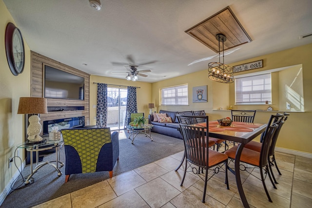 tiled dining space with a textured ceiling and ceiling fan