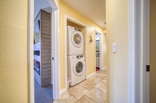 washroom featuring light tile patterned floors and stacked washer and clothes dryer