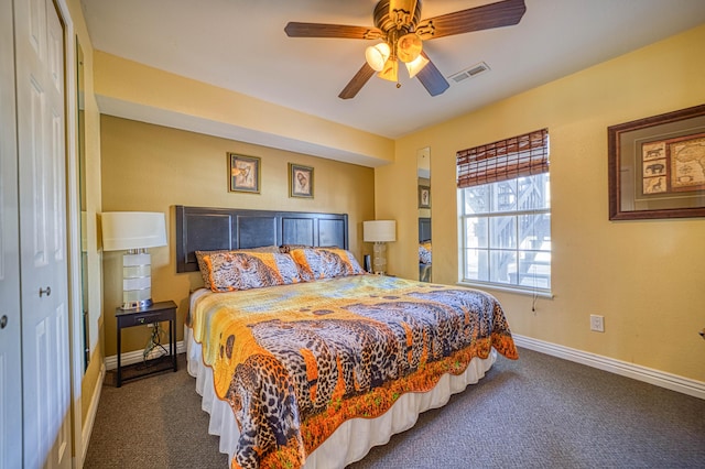 bedroom featuring dark colored carpet, ceiling fan, and a closet