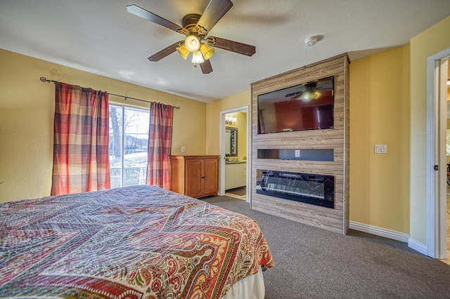 bedroom with ensuite bath, ceiling fan, a fireplace, and carpet floors