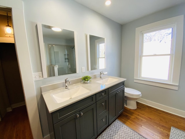 bathroom with toilet, a shower with door, vanity, and hardwood / wood-style flooring