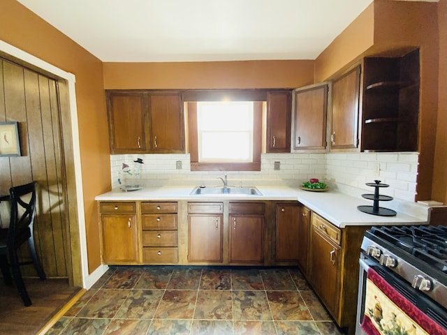 kitchen with tasteful backsplash, stainless steel gas range oven, and sink