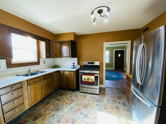 kitchen featuring appliances with stainless steel finishes, tasteful backsplash, and sink