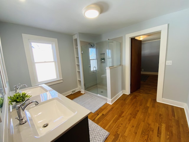 bathroom featuring hardwood / wood-style floors, vanity, and a shower with door