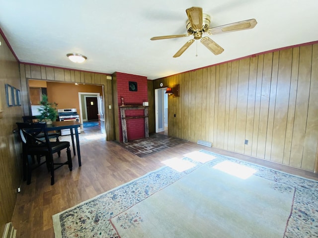 living room with wood walls, dark hardwood / wood-style flooring, and ceiling fan