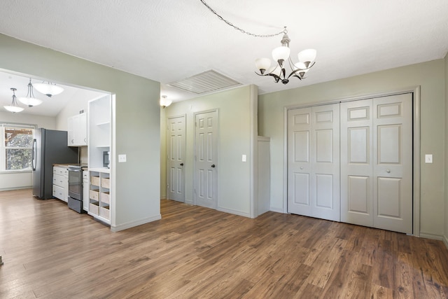 kitchen featuring white cabinets, decorative light fixtures, and dark hardwood / wood-style floors