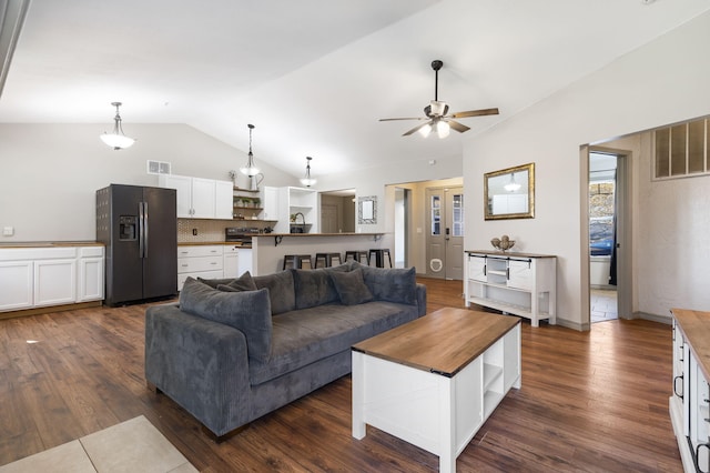 living room featuring dark hardwood / wood-style flooring, ceiling fan, and lofted ceiling