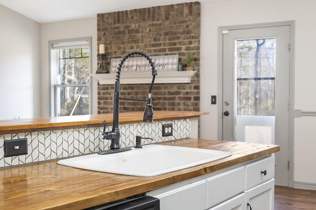 kitchen with hardwood / wood-style flooring, butcher block countertops, and sink