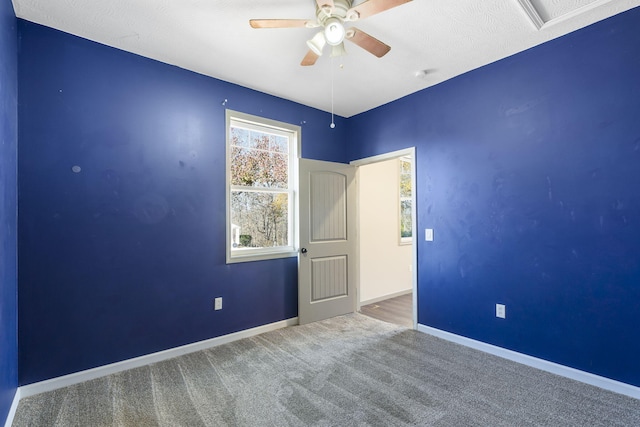 carpeted empty room with ceiling fan and a textured ceiling