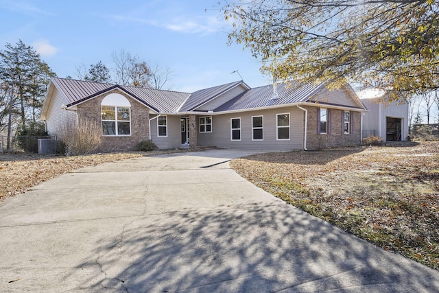 single story home with a garage and central AC unit