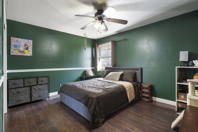 bedroom featuring ceiling fan, dark hardwood / wood-style floors, and a textured ceiling