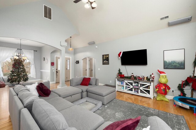 living room featuring high vaulted ceiling, a chandelier, and hardwood / wood-style flooring