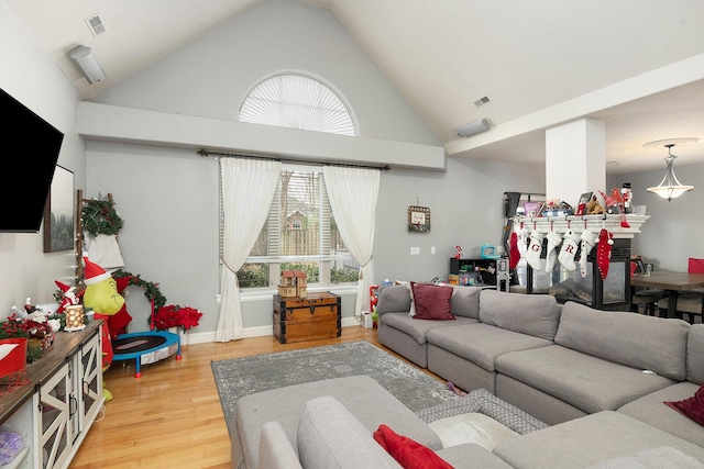 living room with high vaulted ceiling and hardwood / wood-style flooring