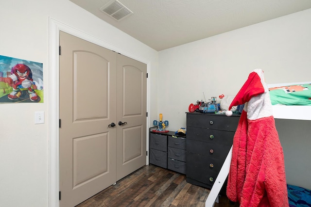 bedroom featuring a textured ceiling and dark wood-type flooring