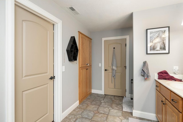 interior space with a textured ceiling and sink