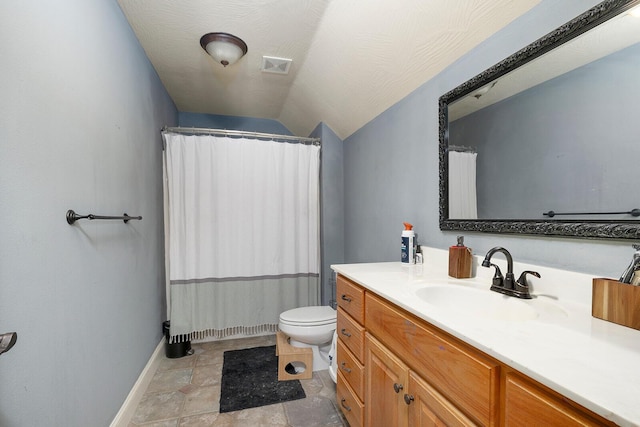 bathroom featuring vanity, toilet, and vaulted ceiling