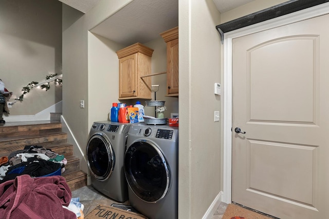 clothes washing area with dark tile patterned floors, cabinets, a textured ceiling, and independent washer and dryer