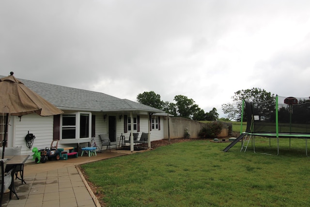 view of yard with a trampoline and a patio area