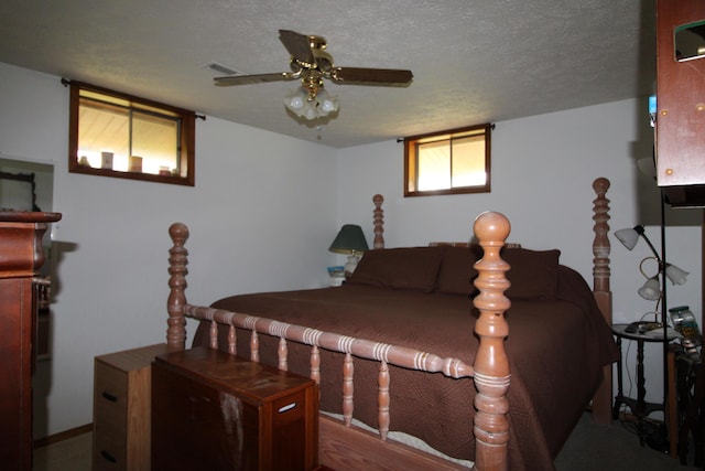 bedroom with ceiling fan and a textured ceiling