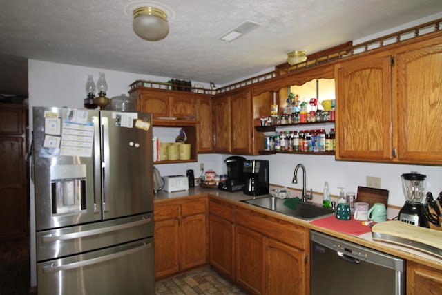 kitchen featuring a textured ceiling, sink, and stainless steel appliances