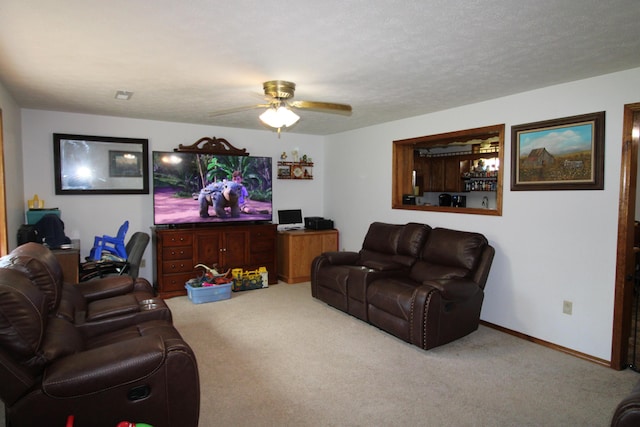 living room with ceiling fan, carpet floors, and a textured ceiling