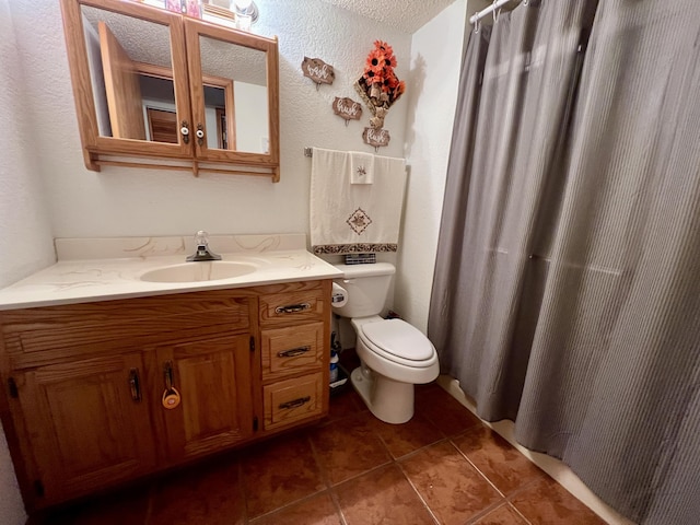 bathroom featuring tile patterned floors, vanity, a textured ceiling, and toilet