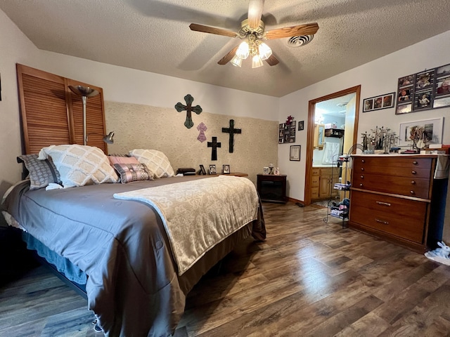 bedroom with ceiling fan, dark hardwood / wood-style flooring, and a textured ceiling