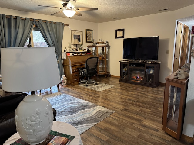 home office with hardwood / wood-style floors, ceiling fan, and a textured ceiling