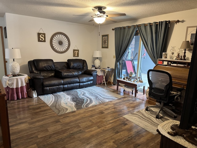 living room with dark hardwood / wood-style floors, ceiling fan, and a textured ceiling