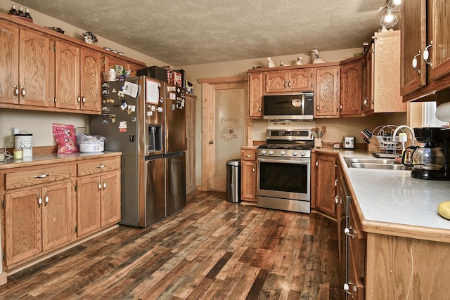 kitchen featuring dark hardwood / wood-style flooring, stainless steel appliances, a textured ceiling, and sink