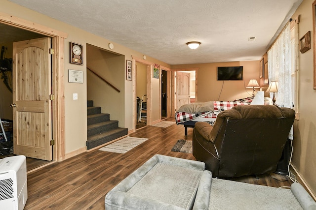 living room featuring dark hardwood / wood-style flooring and a textured ceiling