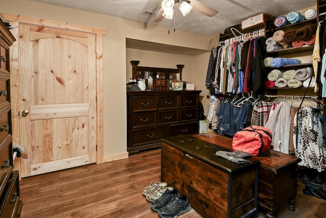 walk in closet with ceiling fan and dark hardwood / wood-style flooring