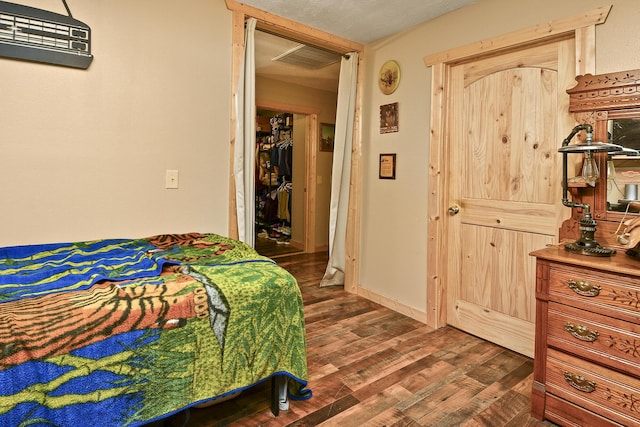 bedroom featuring a textured ceiling and dark hardwood / wood-style flooring