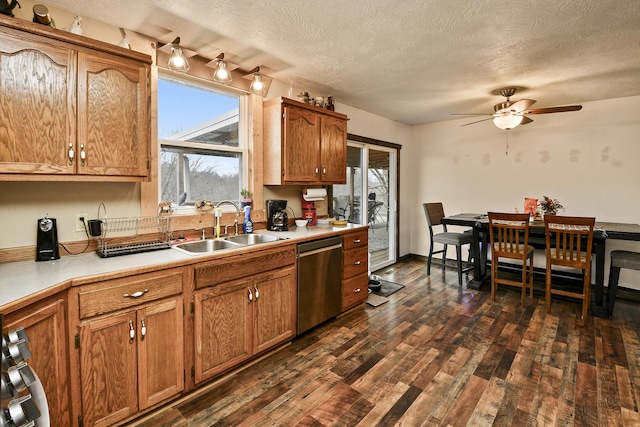 kitchen with dark wood-type flooring, sink, stainless steel dishwasher, and plenty of natural light