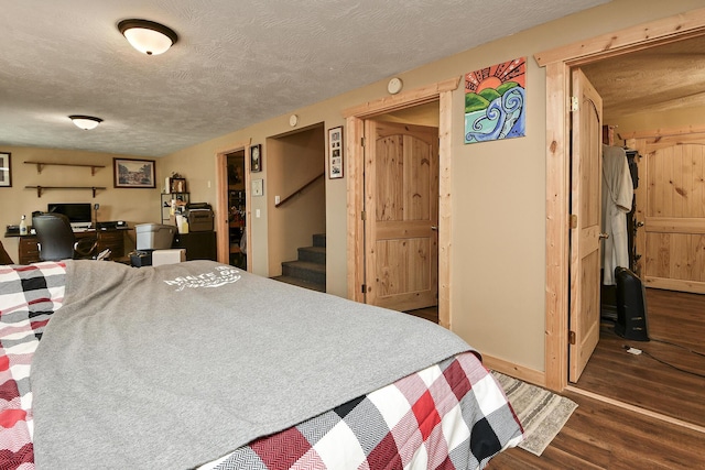 bedroom with a textured ceiling and dark hardwood / wood-style flooring