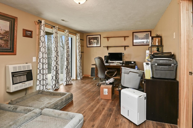 office area with dark wood-type flooring, a textured ceiling, and heating unit