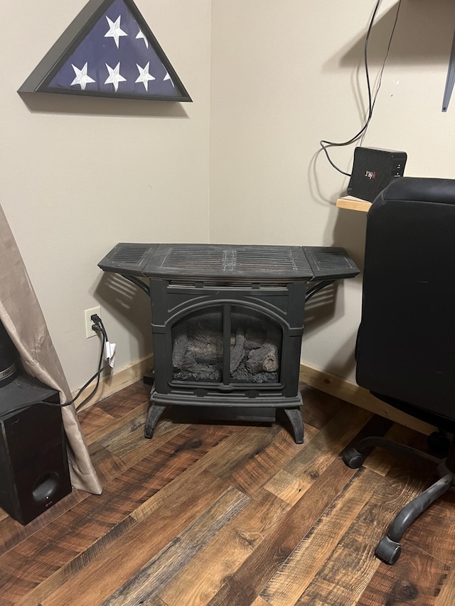 interior details featuring a wood stove and hardwood / wood-style floors