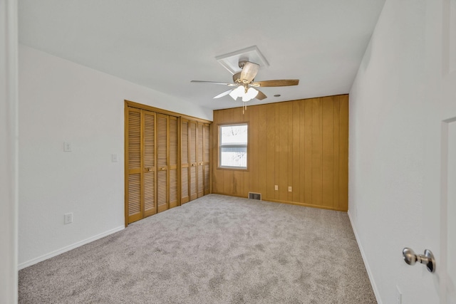 213 Mill St, Anderson, MO 64831 - unfurnished bedroom featuring carpet flooring, baseboards, a closet, a ceiling fan, and wood walls