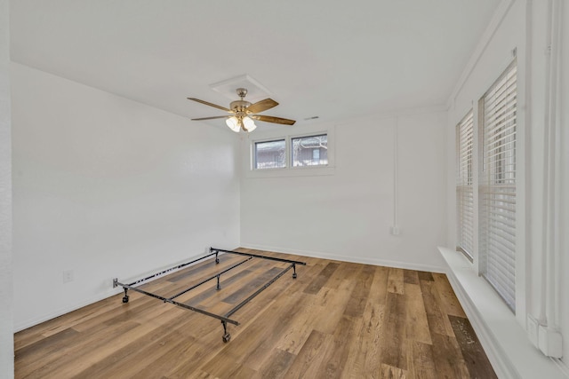 213 Mill St, Anderson, MO 64831 - unfurnished bedroom featuring wood finished floors, baseboards, and a ceiling fan