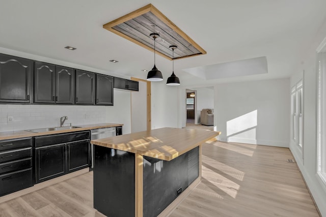 213 Mill St, Anderson, MO 64831 - kitchen featuring dark cabinetry, a sink, decorative backsplash, light wood-type flooring, and light countertops