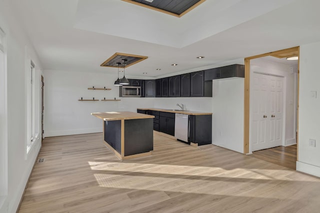 213 Mill St, Anderson, MO 64831 - kitchen featuring appliances with stainless steel finishes, light wood-style floors, dark cabinets, baseboards, and a kitchen island
