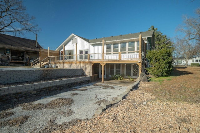 213 Mill St, Anderson, MO 64831 - back of property with board and batten siding and a deck