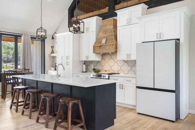 kitchen featuring white cabinets, white refrigerator, sink, and custom exhaust hood